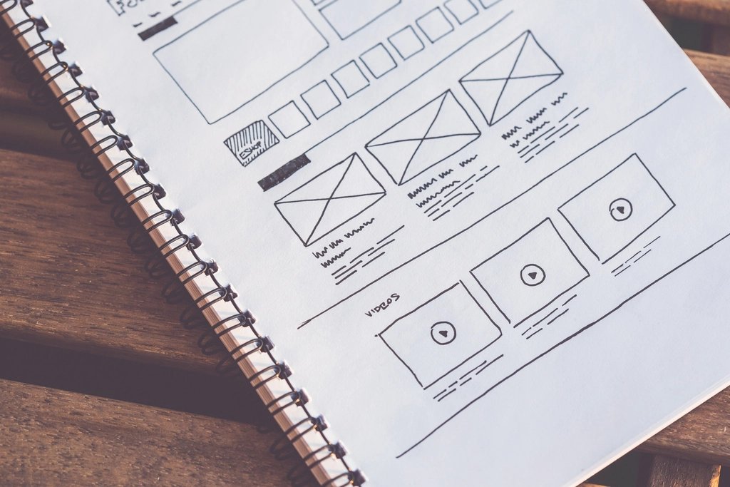 Shopify theme editor open on a laptop showing a clean storefront layout with product grids, navigation, and color settings
